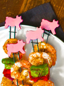 Pig themed grilling skewers with shrimp and vegetables plated with napkin photography by Bayard Heimer